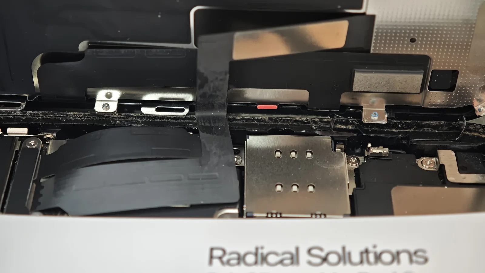 Reziduuri de lichid pe garnitura ramei unui iPhone XR